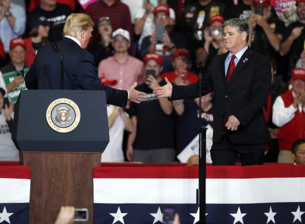 President Donald Trump shakes hands with Fox News Channel's Sean Hannity, right, during a campaign rally Monday, Nov. 5, 2018, in Cape Girardeau, Mo. (AP Photo/Jeff Roberson)