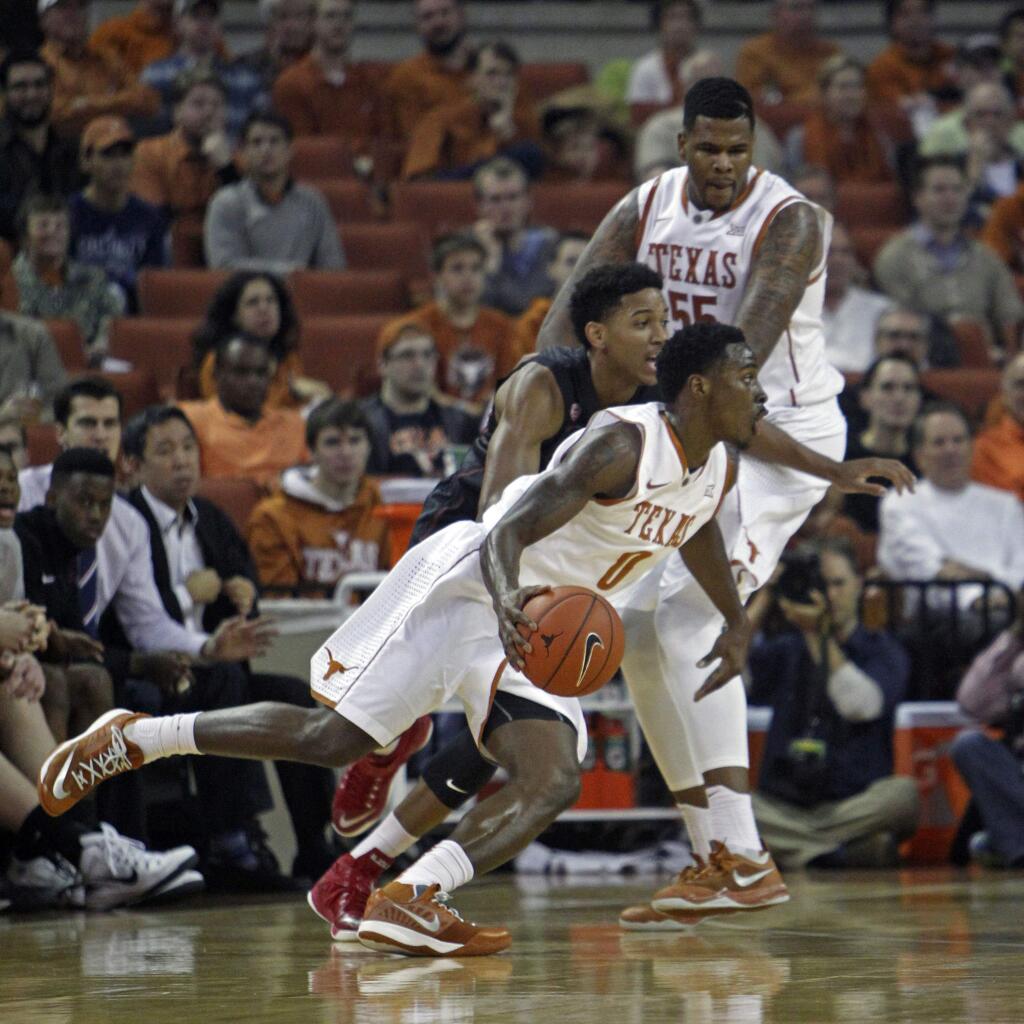 Texas guard Kendal Yancy (0) drives around Stanford guard Anthony Brown (21) with the help of a screen by Texas center Cameron Ridley (55) during the first half of a game, Tuesday, Dec. 23, 2014, in Austin, Texas. (AP Photo/Michael Thomas)
