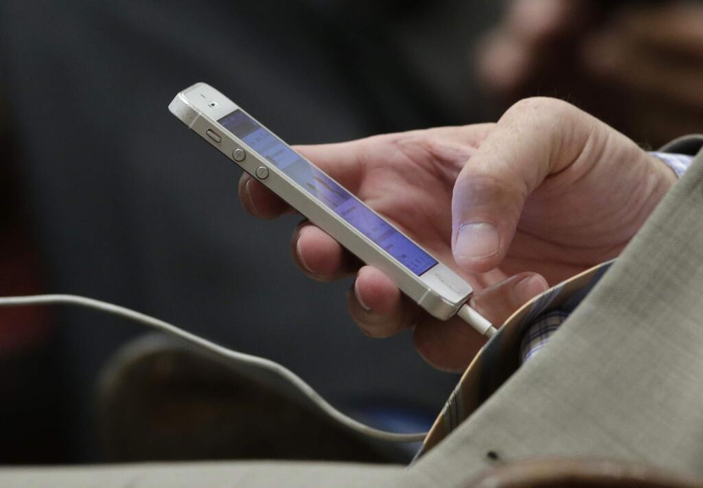 State Sen. Anthony Canella, R-Ceres, uses his smartphone at the Capitol on Monday, Aug. 11, 2014, in Sacramento, Calif. (AP Photo/Rich Pedroncelli)