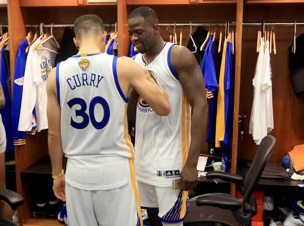 Stephen Curry and Draymond Green talk it over in the locker room after being beat by the Cleveland Cavaliers, 93-89 in game 7 of the NBA Finals, Sunday June 19, 2016. (Kent Porter / Press Democrat) 2016