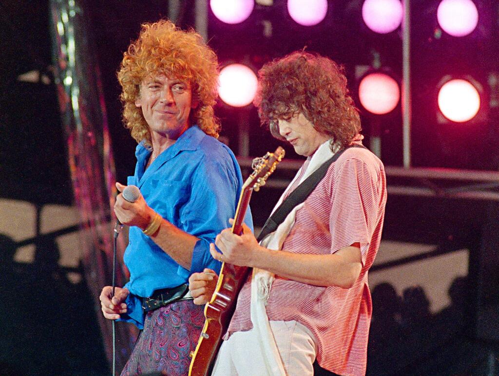 In this July 13, 1985 file photo, Led Zeppelin bandmates, singer Robert Plant, left, and guitarist Jimmy Page, reunite to perform for the Live Aid famine relief concert at JFK Stadium in Philadelphia. (AP Photo/Amy Sancetta, File)