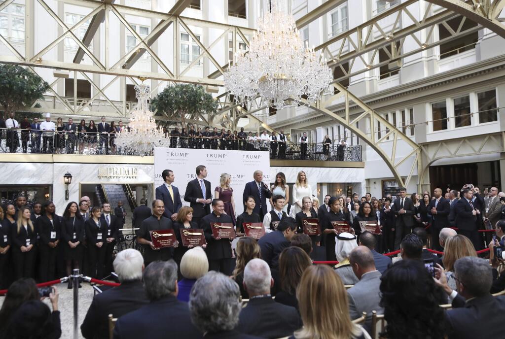 Republican presidential candidate Donald Trump, together with his family, from left, Donald Trump Jr., Eric Trump, Trump, Melania Trump, Tiffany Trump and Ivanka Trump, speaks in the hotel lobby, during the grand opening of Trump International Hotel in Washington, Wednesday, Oct. 26, 2016. Donald Trump and his children hosted an official ribbon cutting ceremony and press conference to celebrate the grand opening of his new hotel. (AP Photo/Manuel Balce Ceneta