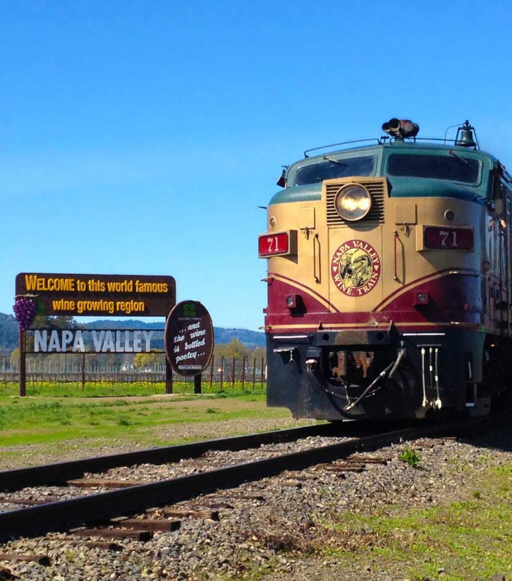 The Wine Train rolls past the Napa Valley welcome sign along Highway 29 north of Yountville in Napa Valley.