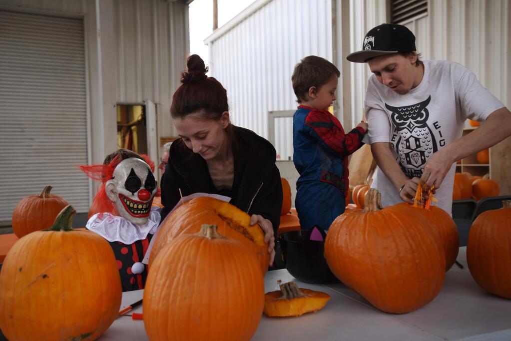 The Boyer family, from left, Skyelir, 9, Kayla, Caleb, 4, and Jordan carving pumpkins during the first annual Halloween Carnival held Friday at 180 Studios in Santa Rosa. The event on Oct. 25, 2019 offered both a pumpkin carving and costume contest along with a creative haunted house. (Photo: Erik Castro/for The Press Democrat)