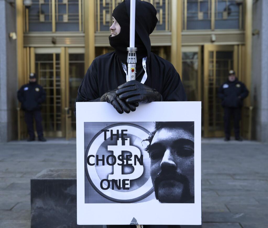 Supporters of Ross William Ulbricht hold signs during the jury selection for his trial outside of federal court in New York, Tuesday, Jan. 13, 2015. Murder-for-hire allegations are central to Ulbrichtt's trial. He is charged with running an online black market where drugs were sold as easily as books and electronics. (AP Photo/Seth Wenig)