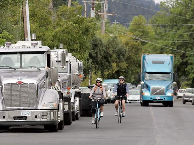 A semi-truck, right, heads down Washington St. with a delivery for Crystal Geyser while two water tankers, left, wait to pump into the Calistoga facility.