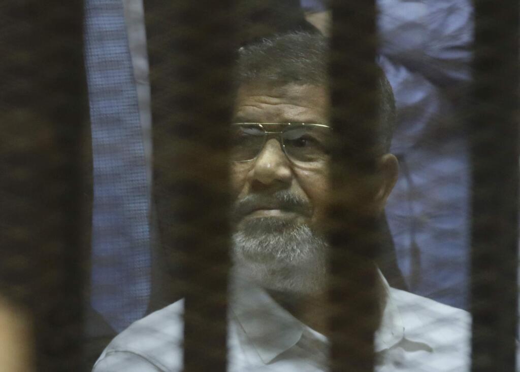 Egypt's ousted Islamist President Mohammed Morsi sits in a soundproof glass cage inside a makeshift courtroom at Egyptís national police academy in Cairo, Egypt, Tuesday, April 21, 2015. An Egyptian criminal court on Tuesday, sentenced Morsi to 20 years in prison over the killing of protesters in 2012, the first verdict to be issued against the countryís first freely elected leader. (AP Photo/Amr Nabil)