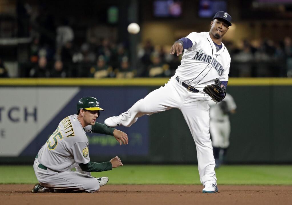 Seattle Mariners shortstop Jean Segura, right, throws to first after forcing out the Oakland Athletics' Stephen Piscotty at second base during the fourth inning Saturday, April 14, 2018, in Seattle. Segura completed the double play on the Athletics' Matt Joyce at first. (AP Photo/Elaine Thompson)