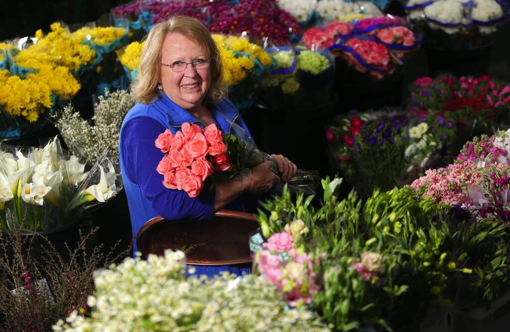 Floral designer Lorrie Abbott, among the fresh cut flowers at Sequoia Floral International, teaches floristry classes through Rohnert Park's recreation department, and has an upcoming Valentine's workshop.(Christopher Chung/ The Press Democrat)