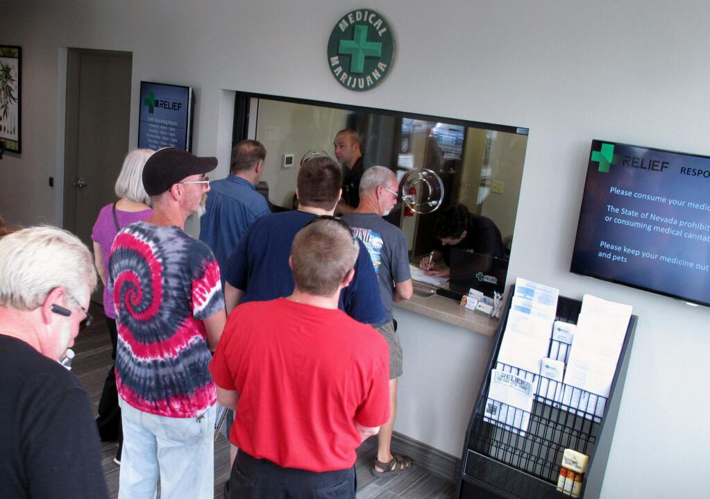 FILE - In this July 31, 2015, file photo, people line up to be among the first in Nevada to legally purchase medical marijuana at the Silver State Relief dispensary in Sparks, Nev. The Mynt is one of at least four medical marijuana dispensaries in Reno that have received the necessary local licenses and are ready to start selling marijuana for recreational use on Saturday, July 1 as long as they get their anticipated state license. (AP Photo/Scott Sonner, File)