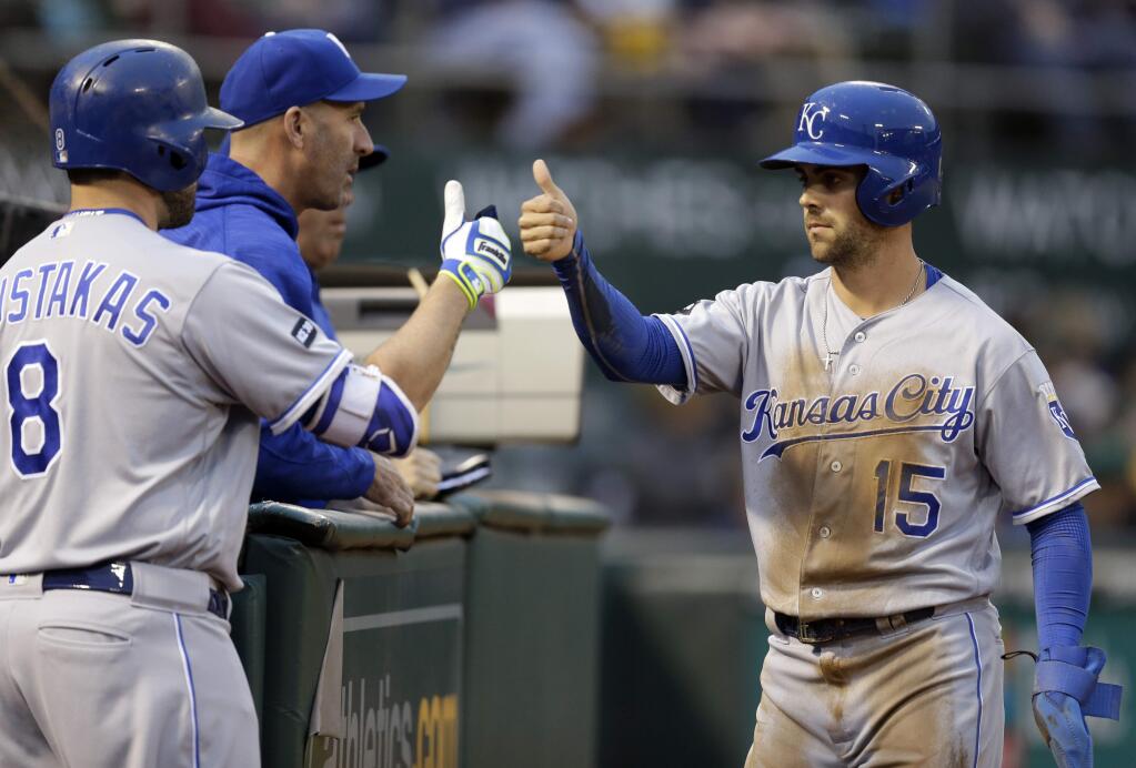 Kansas City Royals' Whit Merrifield, right, celebrates with Mike Moustakas (8) after scoring against the Oakland Athletics in the first inning of a baseball game, Monday, Aug. 14, 2017, in Oakland, Calif. Merrifield scored on a single by Royals' Eric Hosmer. (AP Photo/Ben Margot)