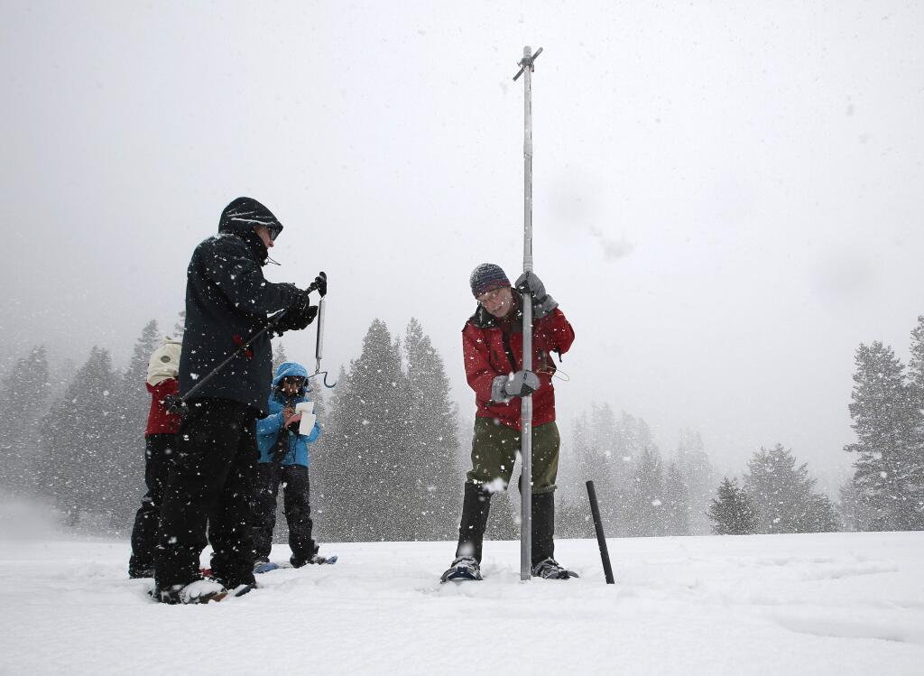 FILE - In this March 30, 2017 file photo, Frank Gehrke, right, chief of the California Cooperative Snow Surveys Program for the Department of Water Resources, lifts the survey tube out of the snowpack depth during the manual snow survey at Phillips Station near Echo Summit, Calif. The National Weather Service says this is now the wettest winter on record in the Northern California mountains. Weather Service officials say an index of precipitation at eight stations in the northern Sierra Nevada surpassed the old record at about 4 a.m. Thursday, April 13, 2017, with just under 90 inches of rain and snow. (AP Photo/Rich Pedroncelli, File)