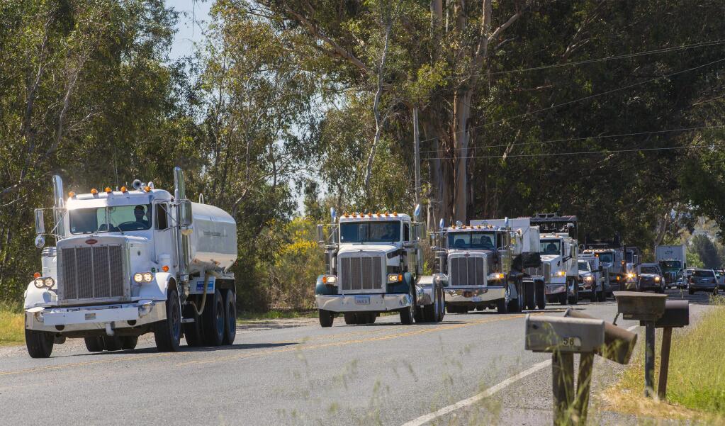 The procession which carried the casket of Earl Broderick from Sears Point to Duggan's Mission Chapel on West Napa Street was as long as the eye could see. A caravan of big trucks passed by Broderick General Engineering headquarters on 8th Street East on Friday, May 1, in honor of Earl Broderick. (Photo by Robbi Pengelly/Index-Tribune).