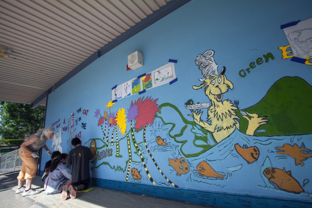 Robbi Pengelly/Index-TribuneFifth-graders and kindergartners helped paint the mural at Sassarini elementary – a mural that somebody recently defaced.