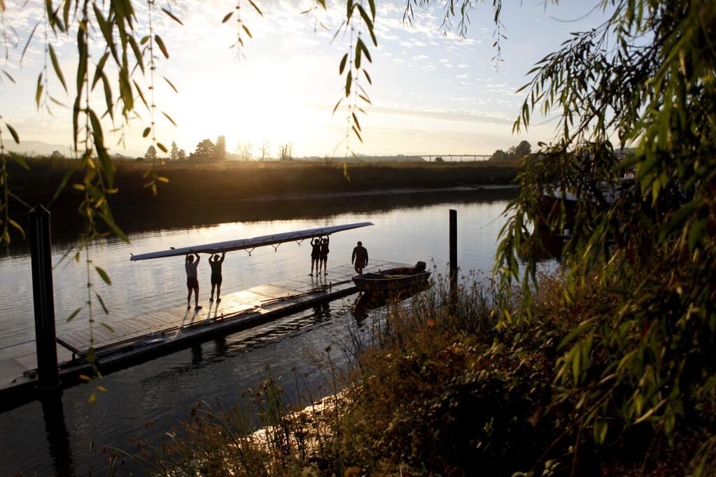 Members of the North Bay Rowing Club prepare to launch their boat for a morning workout on the Petaluma River in 2011. (BETH SCHLANKER / The Press Democrat)