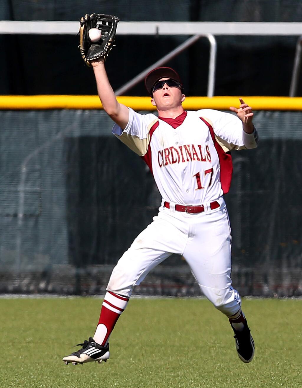 Cardinal Newman's Alex Roeser catches a fly ball during the game against Ukiah, held at Cardinal Newman High School, Friday, April 10, 2015. (CRISTA JEREMIASON / The Press Democrat)