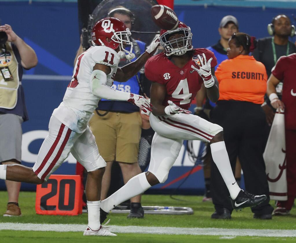 Alabama wide receiver Jerry Jeudy, right, eyes a pass as Oklahoma cornerback Parnell Motley attempts to defend during the second half of the Orange Bowl on Saturday, Dec. 29, 2018, in Miami Gardens, Fla. (AP Photo/Wilfredo Lee)