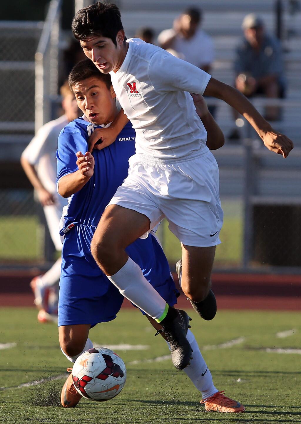 Montgomery's Evan Martinez, right, and Analy's Abel Hernandez, left, fight for the ball during the game held at Montgomery High School, Tuesday, September 9, 2014.(Crista Jeremiason / The Press Democrat)
