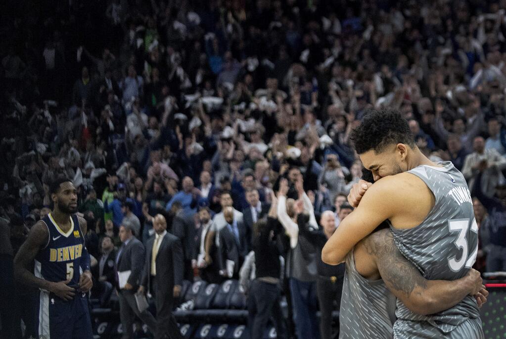 The Minnesota Timberwolves' Karl-Anthony Towns, right, and Jeff Teague celebrate after the team's win against the Denver Nuggets on Wednesday, April 11, 2018, in Minneapolis. (Carlos Gonzalez/Star Tribune via AP)