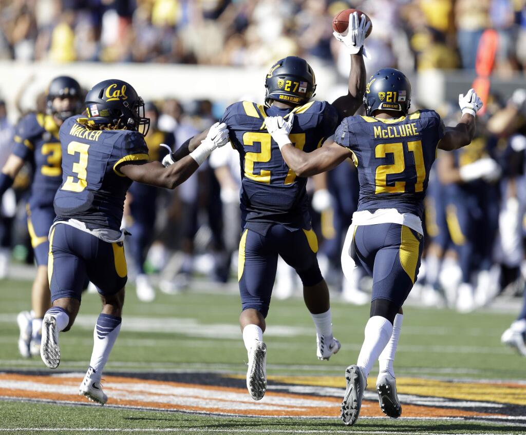 California's Damariay Drew (27), celebrates with Stefan McClure (21) and Cameron Walker, left, after intercepting a pass intended for Washington State's Tyler Baker during the second half Saturday, Oct. 3, 2015, in Berkeley. California won the game 34-28. (AP Photo/Ben Margot)
