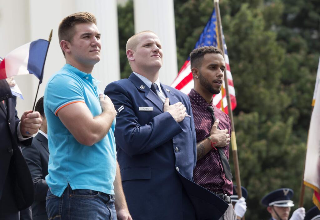 Oregon National Guardsman Alek Skarlatos, left, U.S. Airman Spencer Stone, center, and Anthony Sadler attend a parade held to honor the three Americans who stopped a gunman on a Paris-bound passenger train, Friday, Sept. 11, 2015, in Sacramento, Calif. The three talked about the significance of 9/11 on Friday at the festive parade and in an interview to air on national television. (AP Photo/Carl Costas)
