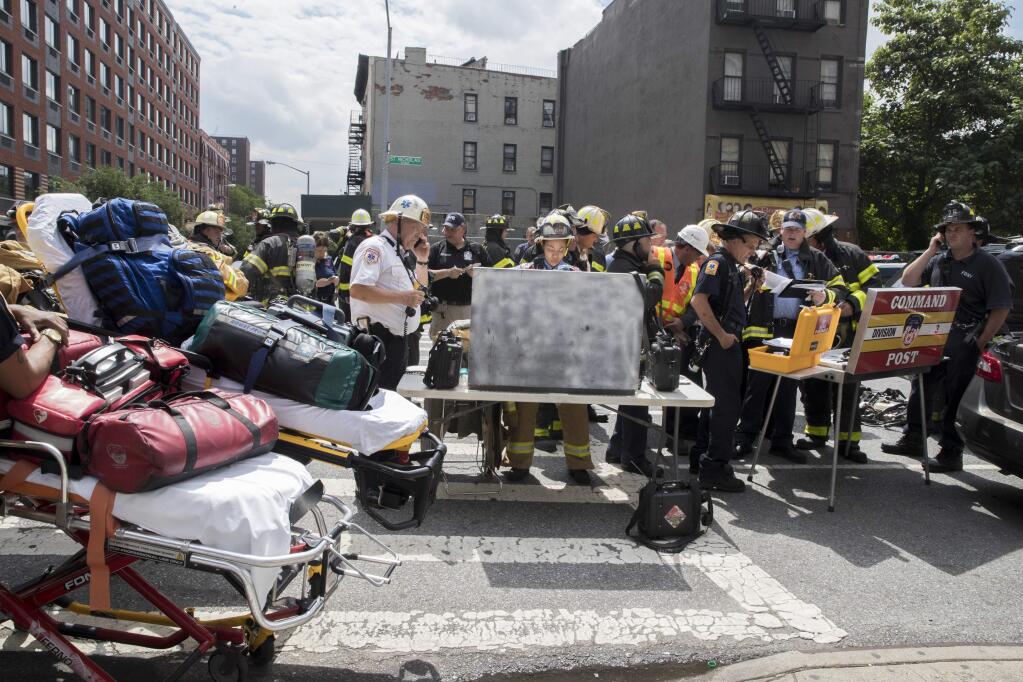 Emergency service personnel work at the scene of a subway derailment, Tuesday, June 27, 2017, in the Harlem neighborhood of New York. A subway train derailed near a station in Harlem on Tuesday, frightening passengers and resulting in a power outage as people were evacuated from trains along the subway line. The Fire Department of New York said a handful of people were treated for minor injuries at around 10 a.m. It said there was smoke but no fire. Delays were reported throughout the subway system. (AP Photo/Mary Altaffer)