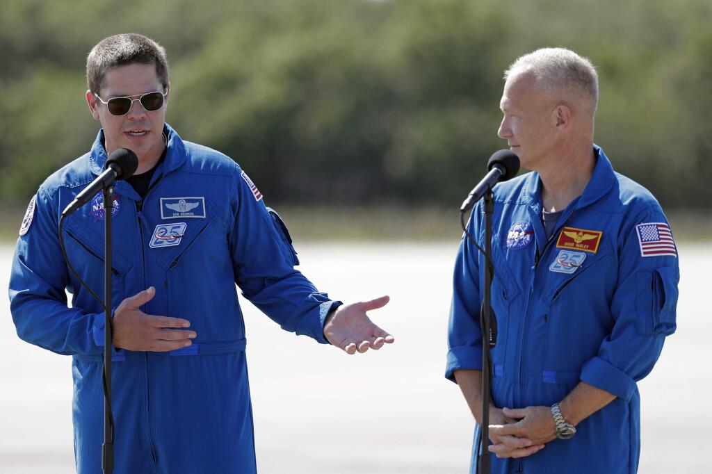 NASA astronauts Robert Behnken, left, and Doug Hurley speak during a news conference after they arrived at the Kennedy Space Center in Cape Canaveral, Fla., Wednesday, May 20, 2020. The two astronauts will fly on the SpaceX Demo-2 mission to the International Space Station scheduled for launch on May 27. (AP Photo/John Raoux)