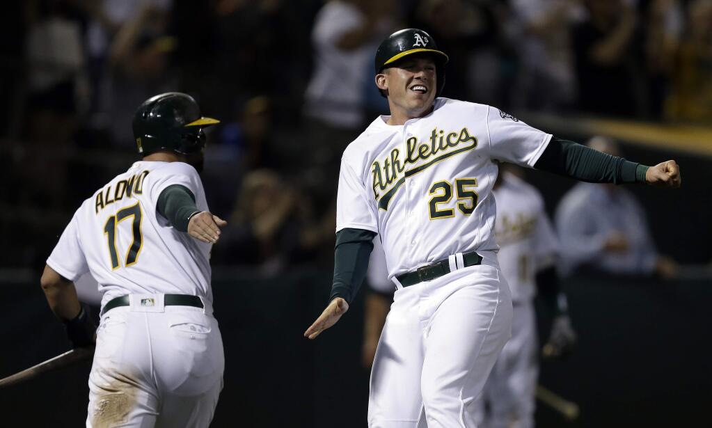 The Oakland Athletics' Ryon Healy, right, and Yonder Alonso celebrate after scoring against the New York Yankees during the eighth inning Friday, June 16, 2017, in Oakland. (AP Photo/Ben Margot)