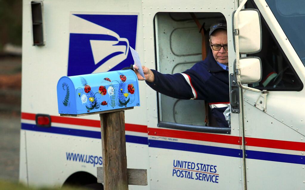 Mail carrier Rick Bertram delivers mail in the Bennett Valley area of Santa Rosa on Friday, December 16, 2016. (John Burgess/The Press Democrat)