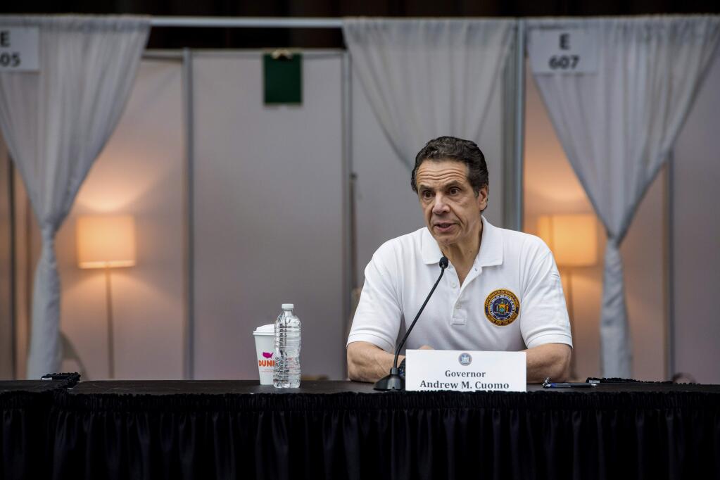 In this Friday, March 27, 2020 photo provided by Office of Governor Andrew M. Cuomo Gov. Andrew Cuomo, briefs the media inside a nearly completed makeshift hospital at the Jacob Javits Convention Center in New York. Cuomo said the state wants to build four more temporary hospitals in New York City within weeks, before coronavirus cases are projected to peak. (Darren McGee/Office of Governor Andrew M. Cuomo via AP)