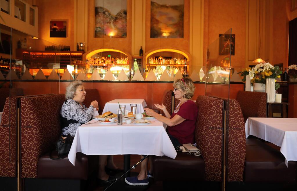 Arlene Rowe, left, and Collette Stricker enjoy lunch at Ristorante Allegria, in Napa on Friday, May 29. Though the restaurant installed clear plastic barriers between tables in their indoor dining area, it was ordered to close indoor dining on July 13 along with all California restaurants because of rising coronavirus numbers. (Christopher Chung/ The Press Democrat)