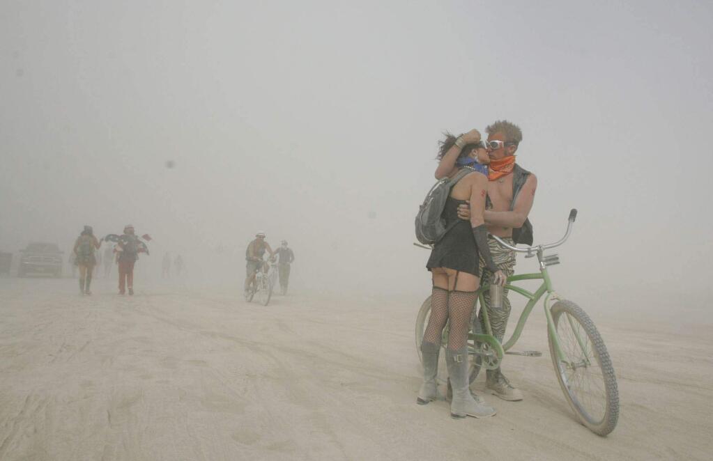 ZigZag, left, and Christ, kiss during a dust storm on the playa during the Burning Man festival near Gerlach, Nev., on Saturday, Aug. 30, 2008, at the Black Rock Desert. (AP Photo/Brad Horn)