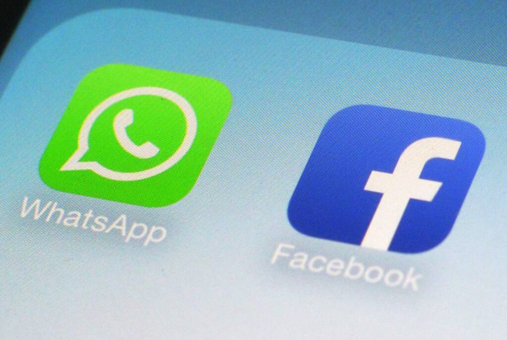 This Feb. 19, 2014, file photo shows WhatsApp and Facebook app icons on a smartphone in New York. Apple’s forthcoming iPhone operating system will allow more control over how such apps can track users’ online behavior. (AP Photo/Patrick Sison)