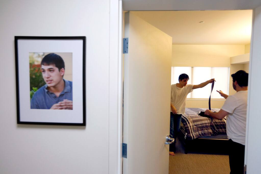Sweetwater Spectrum resident Matthew, left, hands his belt to support staff member Oscar Padilla to help him finish getting dressed in his room at Sweetwater Spectrum, a residential community for adults with autism, in Sonoma, California on Thursday, January 21, 2016. (Alvin Jornada / The Press Democrat)