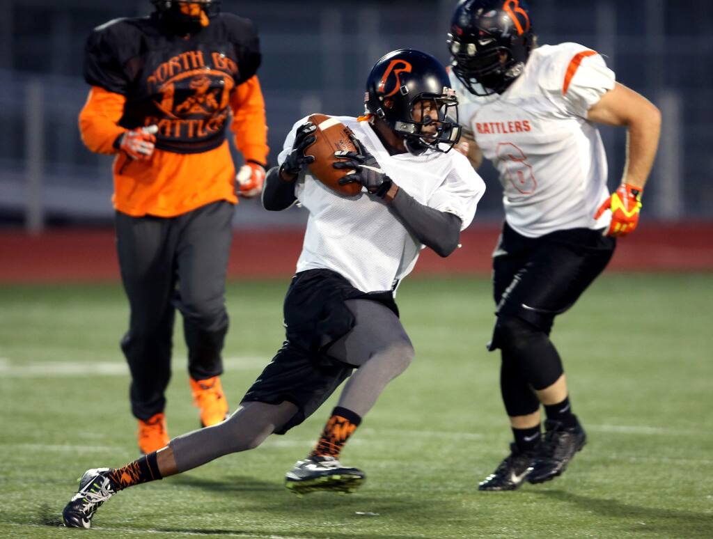 Timothy McDowell, center, runs the ball during the North Bay Rattlers football practice held at Elsie Allen High School, Tuesday, April 28, 2015. (CRISTA JEREMIASON / The Press Democrat)