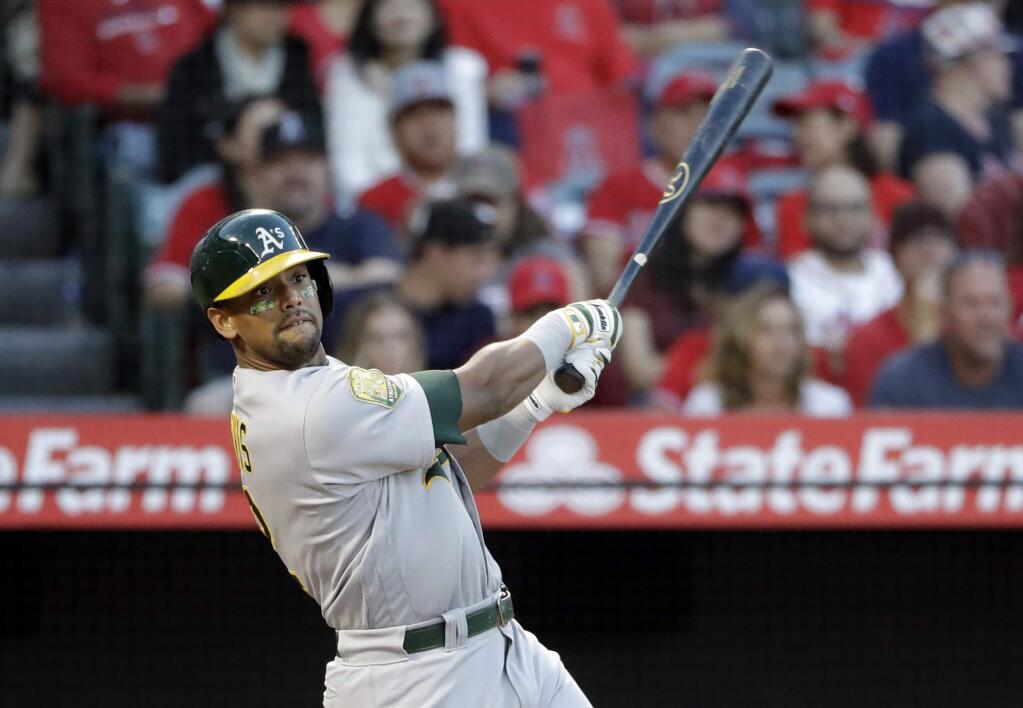FILE - In a Sept. 29, 2018 file photo, Oakland Athletics' Khris Davis follows through on his two-run home run against the Los Angeles Angels during the first inning of a baseball game, in Anaheim, Calif. Majors home run leader Khris Davis would like a multiyear deal from the Oakland Athletics to stay with the franchise ‚Äúat least three more years.‚Äù (AP Photo/Marcio Jose Sanchez, File)