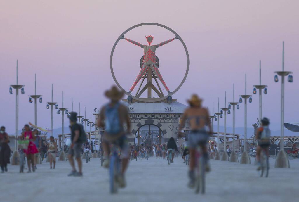In this Wednesday, Aug. 31, 2016 photo, the Burning Man effigy, modeled after the Leonardo da Vinci's Vitruvian Man, stands above the playa during Burning Man at the Black Rock Desert north of Reno, Nev. (Chase Stevens/Las Vegas Review-Journal via AP)