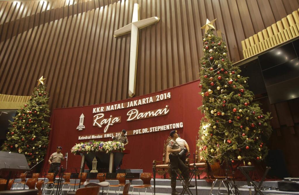 Members of Indonesian Police bomb squad search for suspicious materials to anticipate terror attacks prior to the Christmas Eve mass at the Messiah Cathedral (Katedral Mesias) in Jakarta, Indonesia, Wednesday, Dec. 24, 2014. (AP Photo/Achmad Ibrahim)