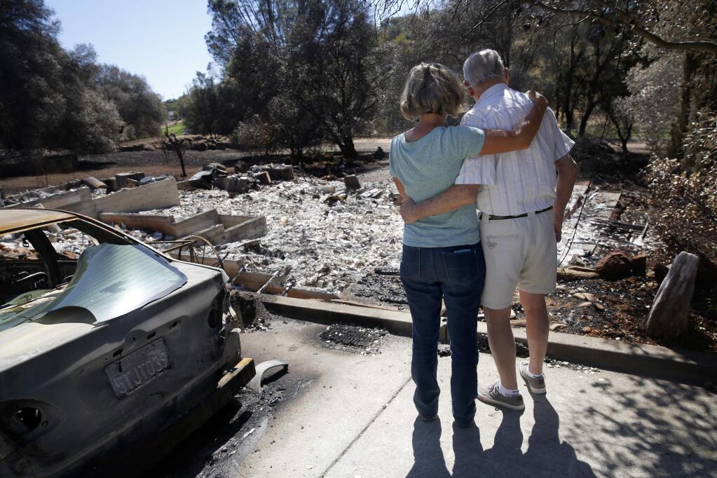 Oliver Smith and his daughter Donna Berggren survey the damage to his Hidden Valley Lake home after the Valley fire. (BETH SCHLANKER / The Press Democrat)