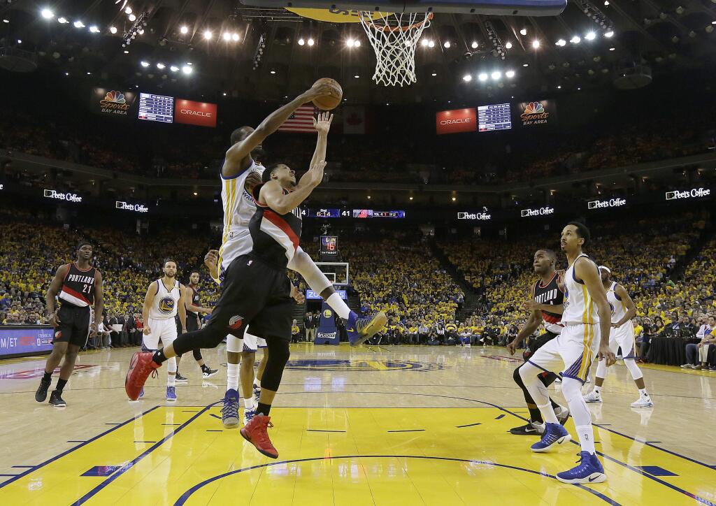Portland Trail Blazers guard C.J. McCollum, foreground, shoots in front of Golden State Warriors forward Kevin Durant during the first half of Game 1 of a first-round NBA basketball playoff series in Oakland, Calif., Sunday, April 16, 2017. (AP Photo/Jeff Chiu)