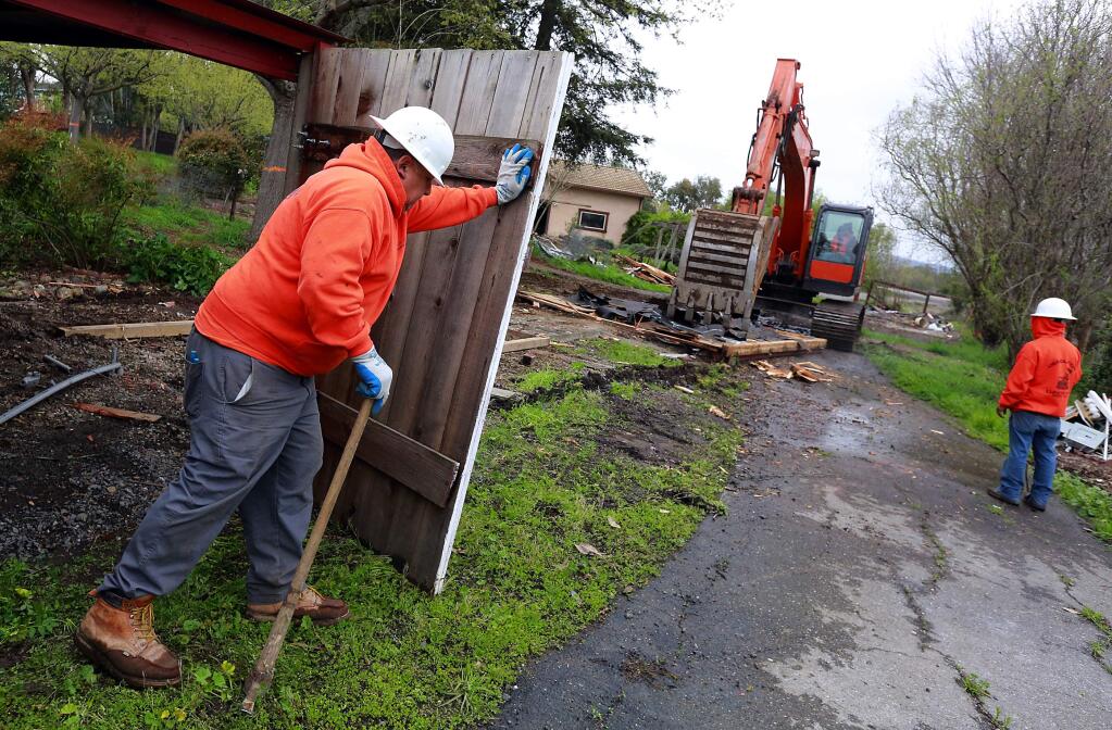 Feliz Orozco demolishes the doors of a Windsor River Rd. garage on land owned by the Lytton Band of Pomo Indians. The tribe will demolish about eight homes to make way for a proposed housing project on the land just west of Windsor. (JOHN BURGESS/The Press Democrat)