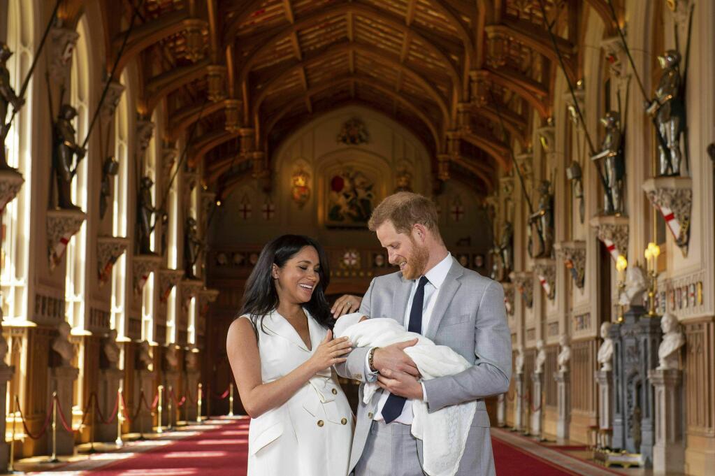 Britain's Prince Harry and Meghan, Duchess of Sussex, during a photocall with their newborn son, in St George's Hall at Windsor Castle, Windsor, south England, Wednesday May 8, 2019. Baby Sussex was born Monday at 5:26 a.m. (0426 GMT; 12:26 a.m. EDT) at an as-yet-undisclosed location. An overjoyed Harry said he and Meghan are 'thinking' about names. (Dominic Lipinski/Pool via AP)