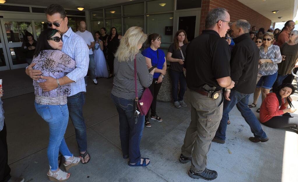 Jenie and Ronnie Fisher embrace at Santa Rosa Junior College as they wait word of their daughter Taylor Crowder and her Santa Rosa High School classmates safety, during a lockdown on the campus due to a report of student with a gun on campus, Friday, May 31, 2019. (Kent Porter / The Press Democrat) 2019