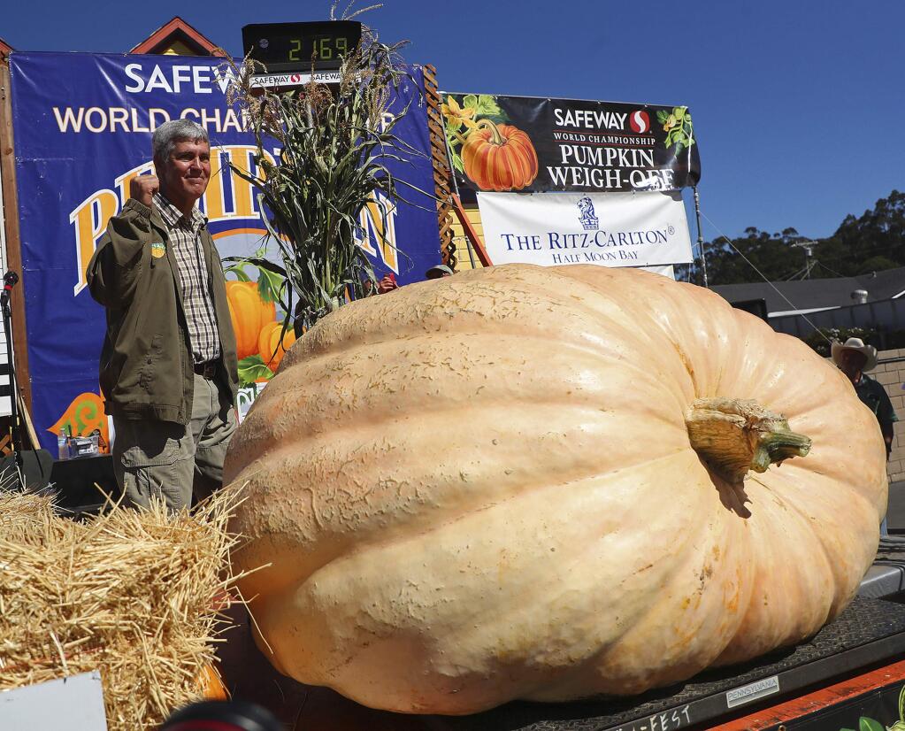 Steve Daletas of Pleasant Hill, Ore., celebrates his first place win in the 45th annual Safeway World Championship Pumpkin Weigh-Off on Monday, Oct. 8, 2018, in Half Moon Bay, Calif. A commercial pilot from Oregon raised a giant pumpkin weighing 2,170 pounds (984 kilograms) to win a pumpkin-weighing contest in Northern California. Daletas credited a good seed and lots of sunny days since he planted it April 15. It is the fourth time Daleta takes top honors at the annual pumpkin-weighing contest. (Aric Crabb/Bay Area News Group via AP)
