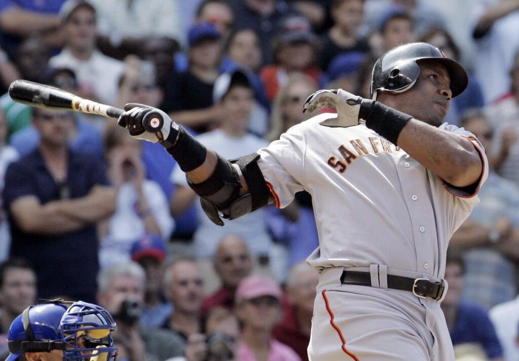FILE - In this July 19, 2007, file photo, San Francisco Giants' Barry Bonds hits a three-run home run during the seventh inning of a baseball game against the Chicago Cubs in Chicago. Barry Bonds, Roger Clemens have moved on, their names cleared. Still, the cloud of steroids remains over baseball and all sports. (AP Photo/M. Spencer Green, File)