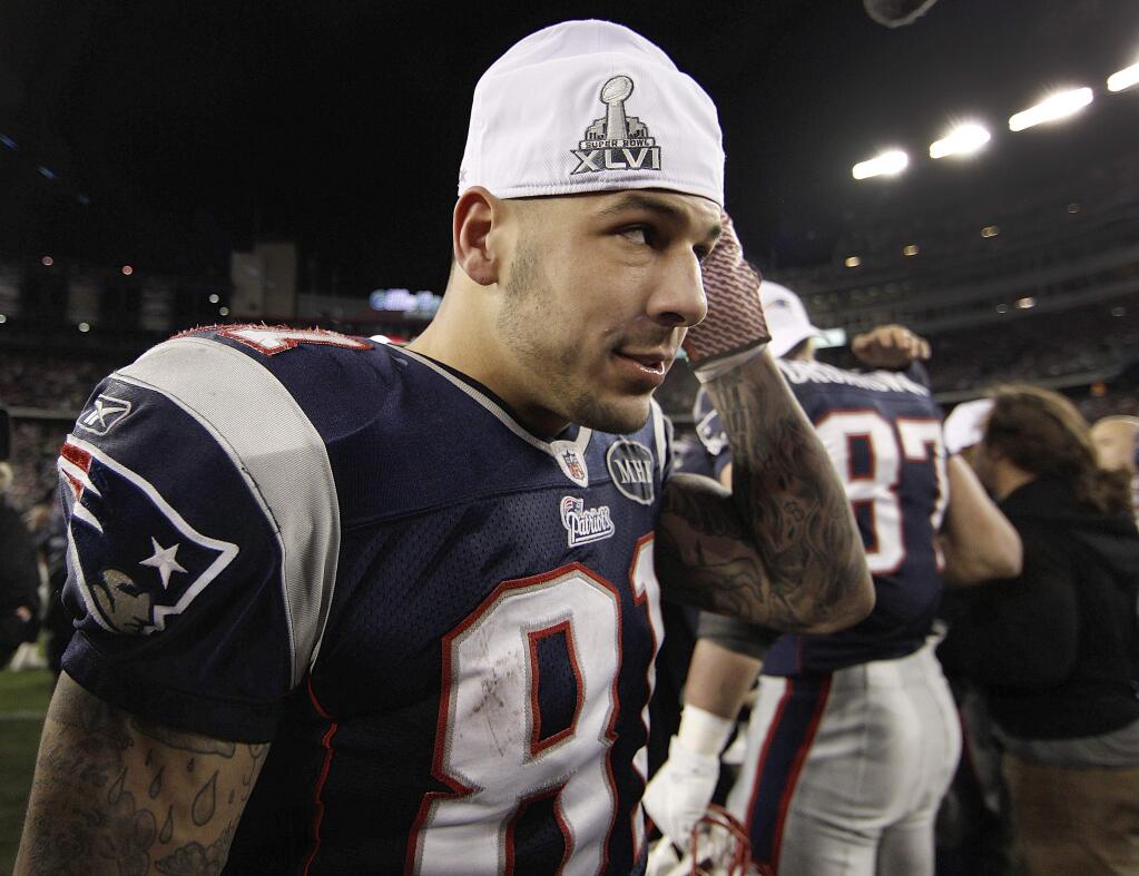 FILE - In this Sunday, Jan. 22, 2012, file photo, New England Patriots tight end Aaron Hernandez puts on a Super Bowl cap following the AFC Championship NFL football game against the Baltimore Ravens in Foxborough, Mass. Hernandez, who was serving a life sentence for a murder conviction and just days ago was acquitted of a double murder, died after hanging himself in his prison cell Wednesday, April 19, 2017, Massachusetts prisons officials said. (AP Photo/Winslow Townson, File)