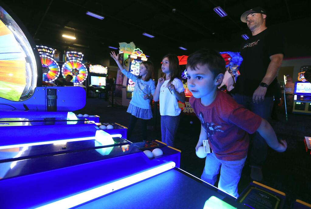 Epicenter, a sports and entertainment complex opened in Santa Rosa earlier this year. From left, Abby Kerzmarki, 7, Elizabeth Simon, 11, and Ethan Simon, 4 play Iceball in the Game On Arcade at Epicenter Sports & Entertainment Center in Santa Rosa. (John Burgess/The Press Democrat)