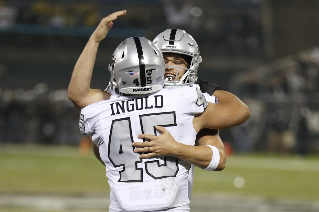 Oakland Raiders running back Alec Ingold (45) celebrates with quarterback Derek Carr after they connected on a touchdown pass against the Los Angeles Chargers during the first half in Oakland, Thursday, Nov. 7, 2019. (AP Photo/D. Ross Cameron)