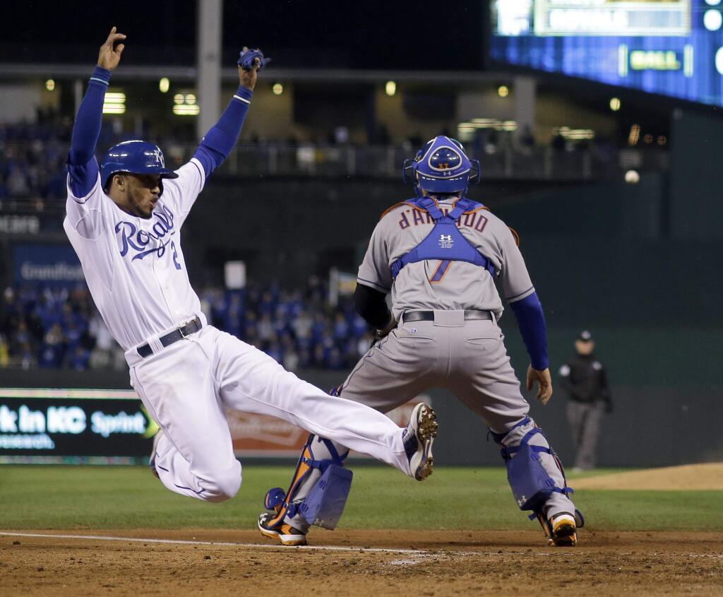 Kansas City Royals' Alcides Escobar, left, scores past New York Mets catcher Travis d'Arnaud on a single by Eric Hosmer during the fifth inning of Game 2 of the Major League Baseball World Series Wednesday, Oct. 28, 2015, in Kansas City, Mo. (AP Photo/Matt Slocum)
