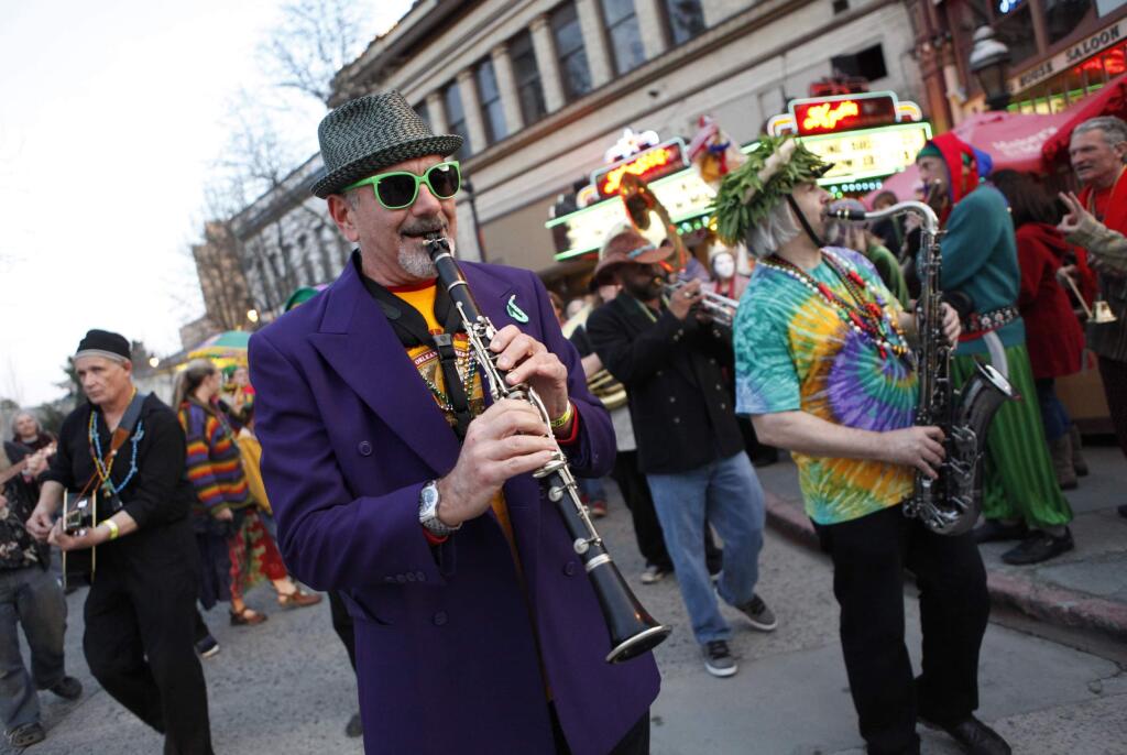 Ken 'Snakebite' Jacobs, center, on clarinet and Michael Peloquin, right, on tenor sax play with the group, Rhythmtown Jive, during a Mardi Gras parade in Petaluma, California, on Tuesday, February 21, 2012. (BETH SCHLANKER/ The Press Democrat)